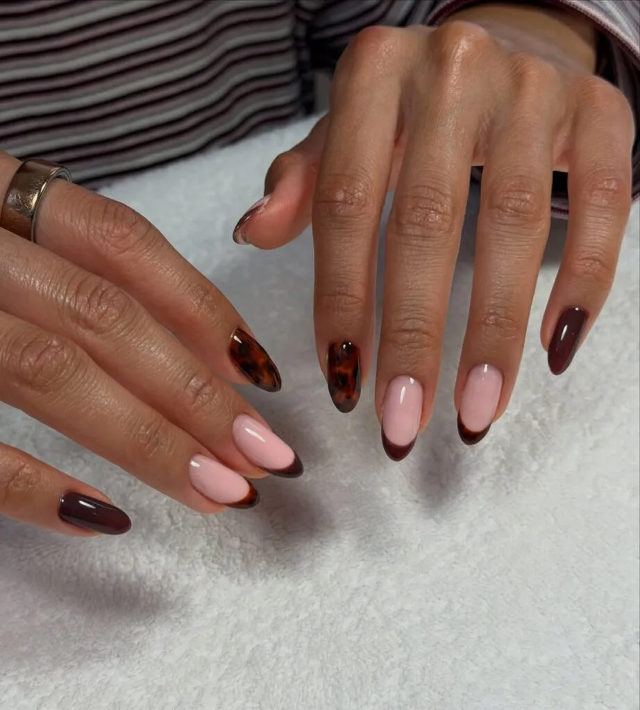 Autumn nails with tortoiseshell accents, dark brown polish, and glossy mocha French tips.
