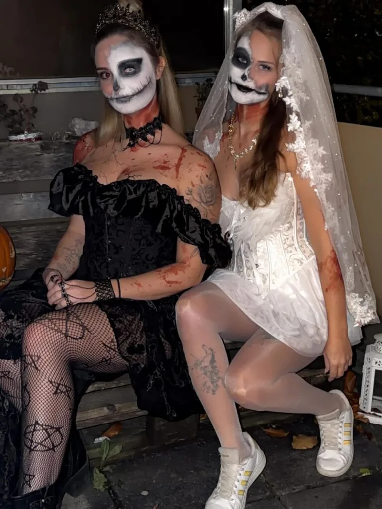 Skeleton queen and bride costumes for best friends with skull makeup, black and white corsets, a crown, and a veil.