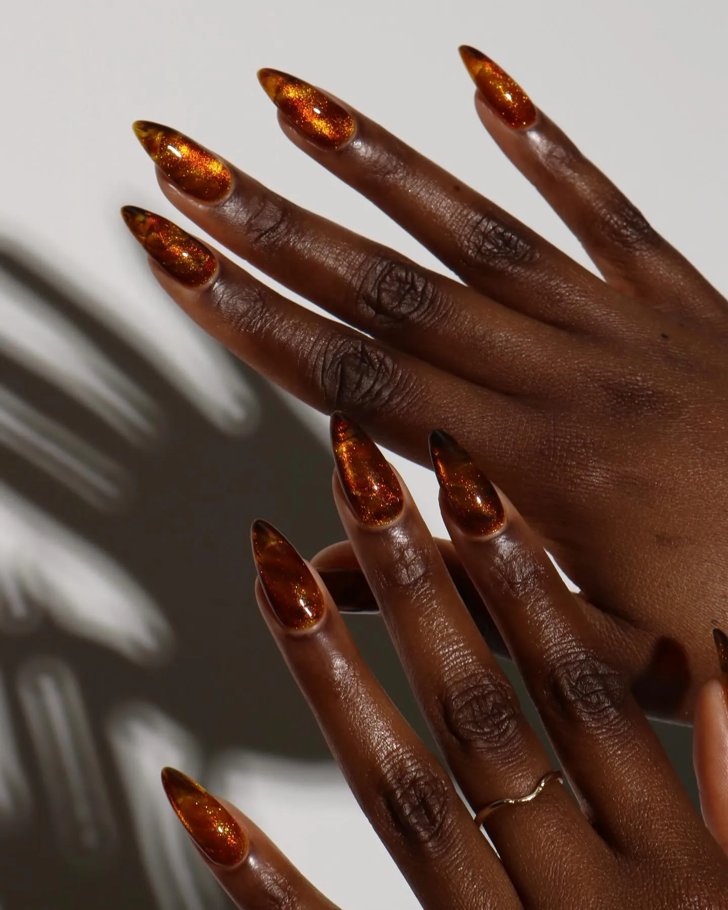 Long almond autumn nails in sheer amber jelly with a golden cat-eye shimmer