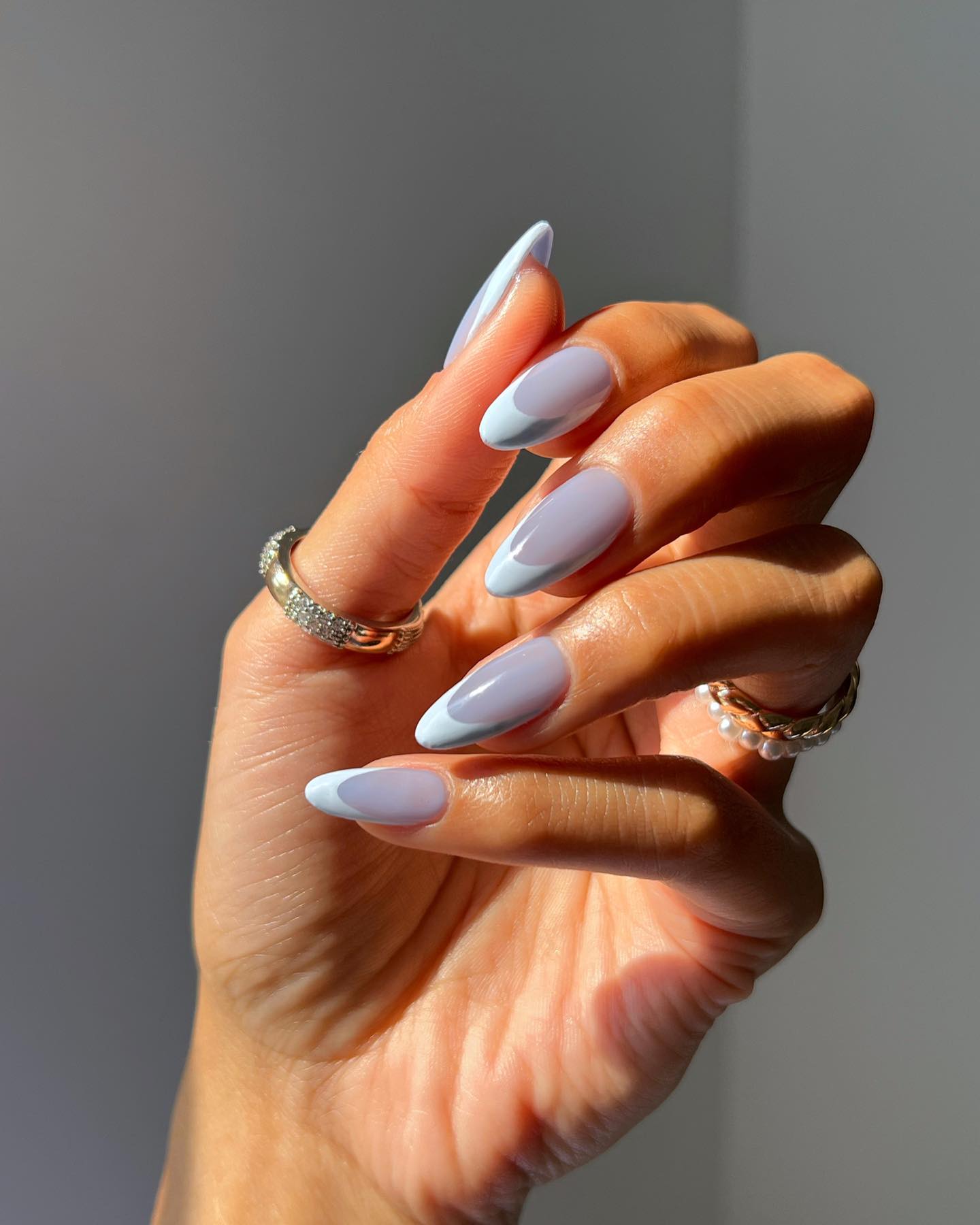 Long almond autumn nails with a sheer lavender-blue base and powder blue French tips