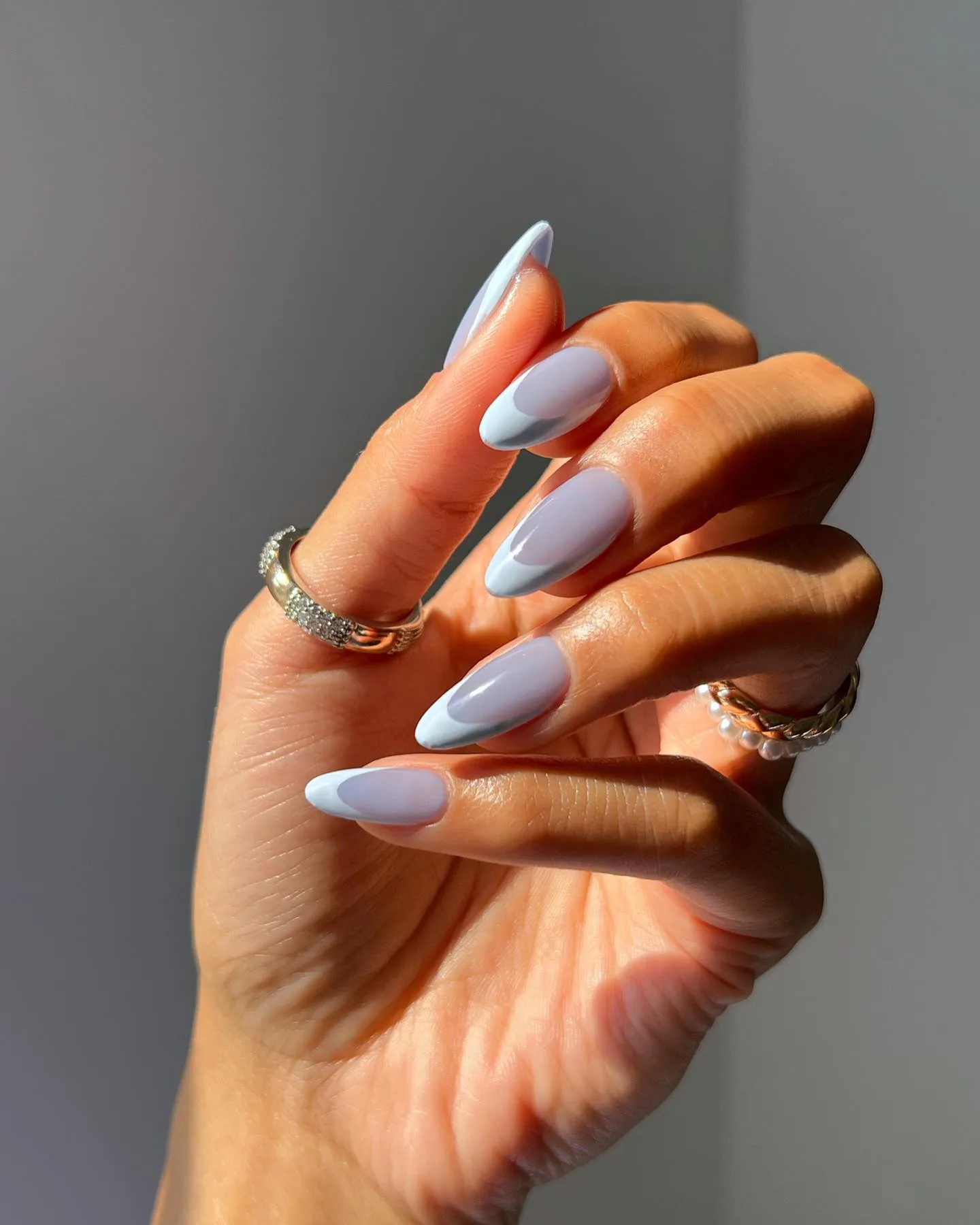 Long almond autumn nails with a sheer lavender-blue base and powder blue French tips