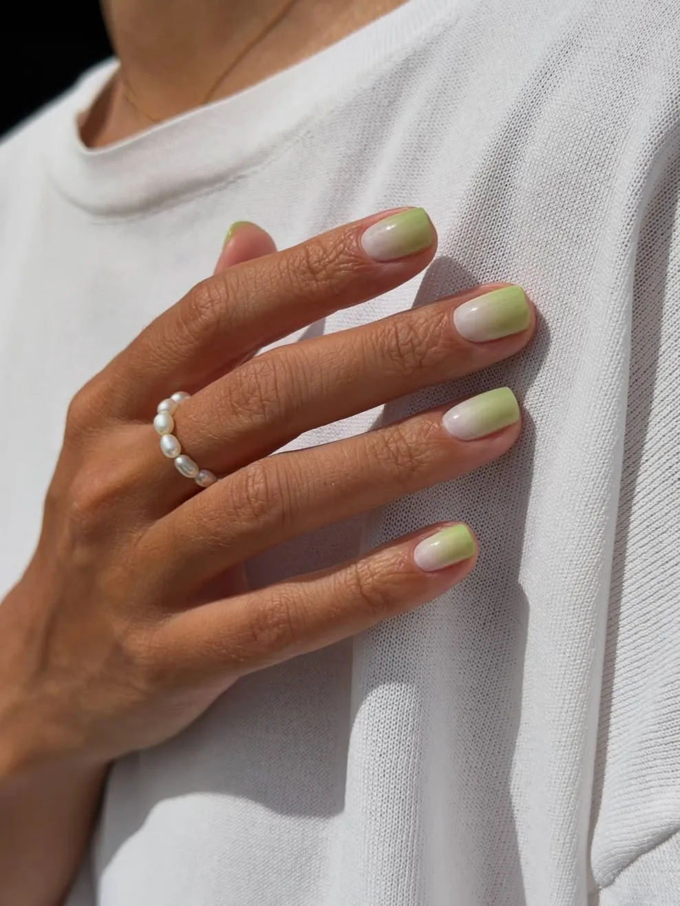 Short square November nail colors with a milky white base fading into soft matcha green tips