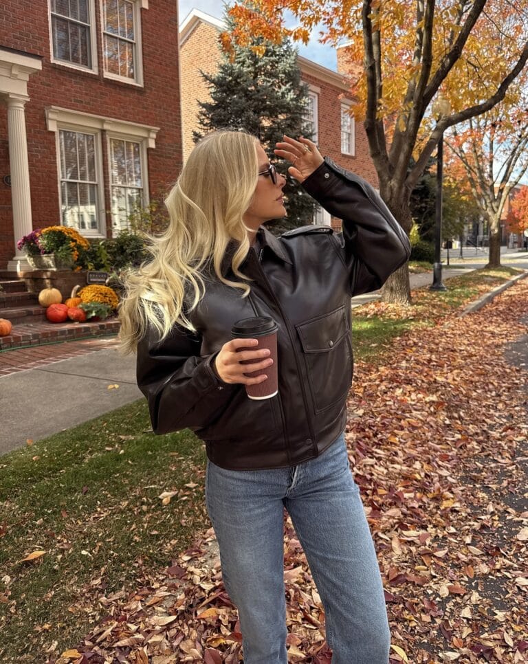 Casual fall outfit with dark brown leather bomber, cuffed light wash jeans, white socks, and brown suede loafers
