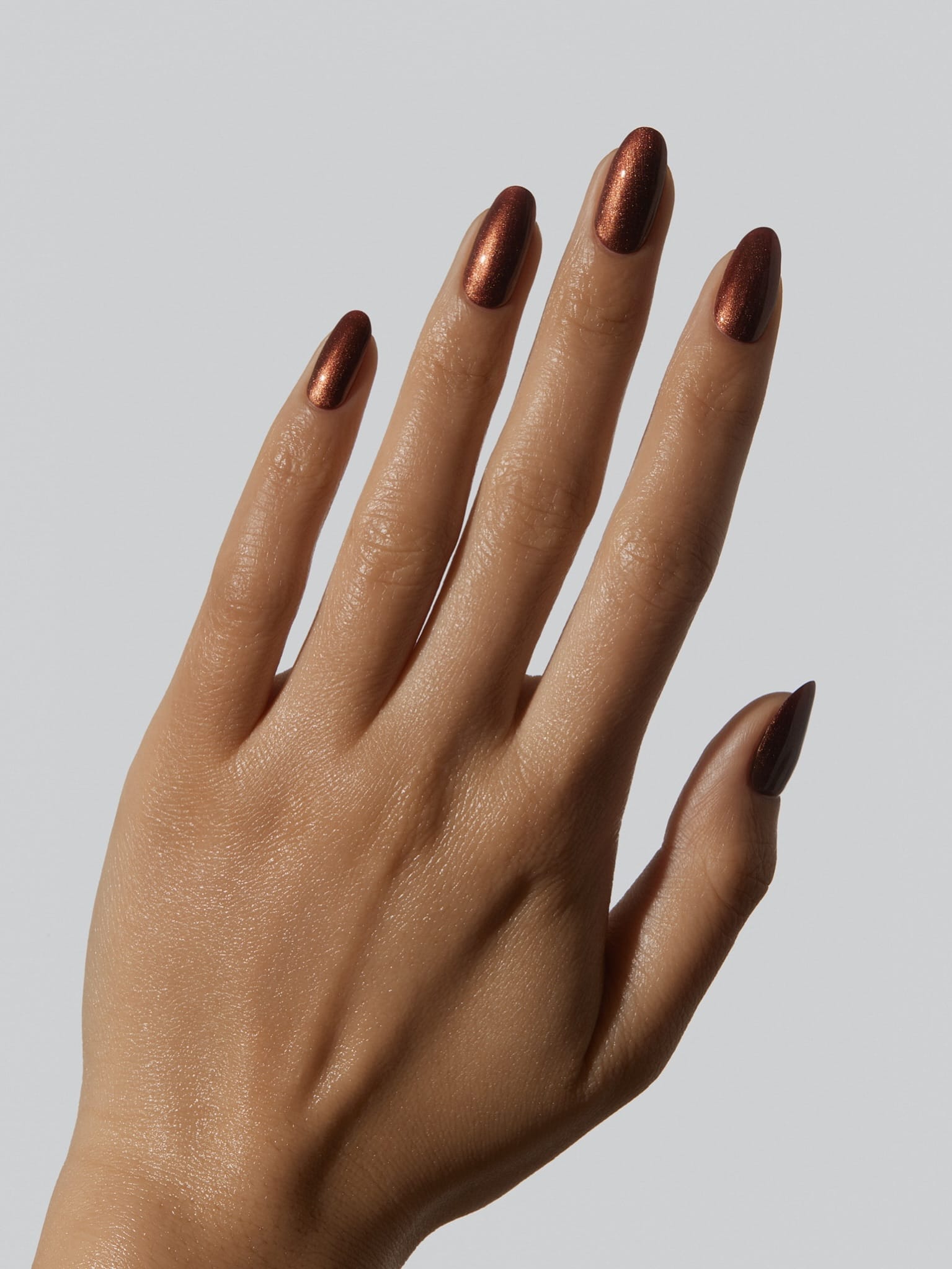 Almond November nail colors in a copper-brown metallic shimmer with a glossy finish