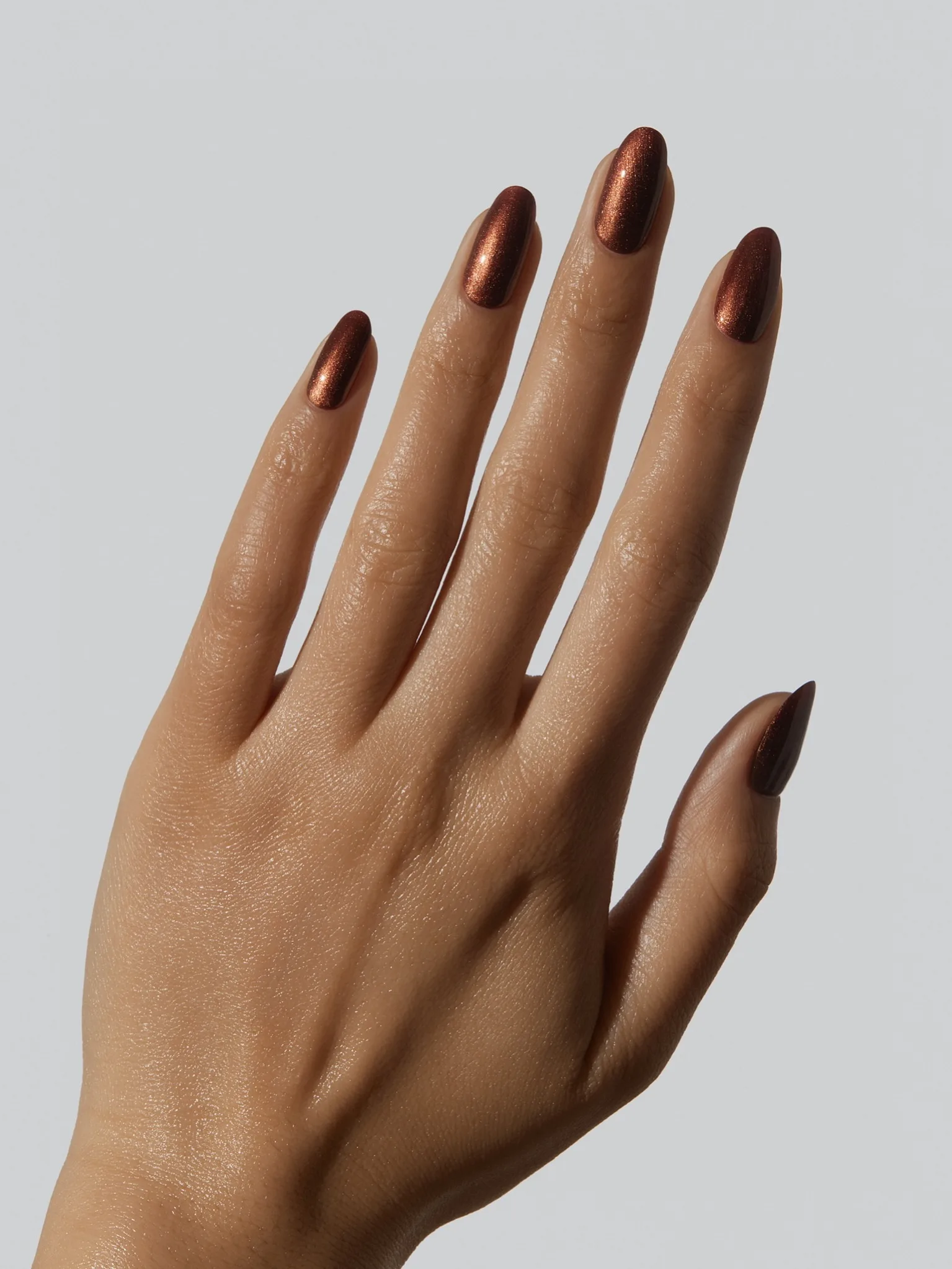 Almond November nail colors in a copper-brown metallic shimmer with a glossy finish